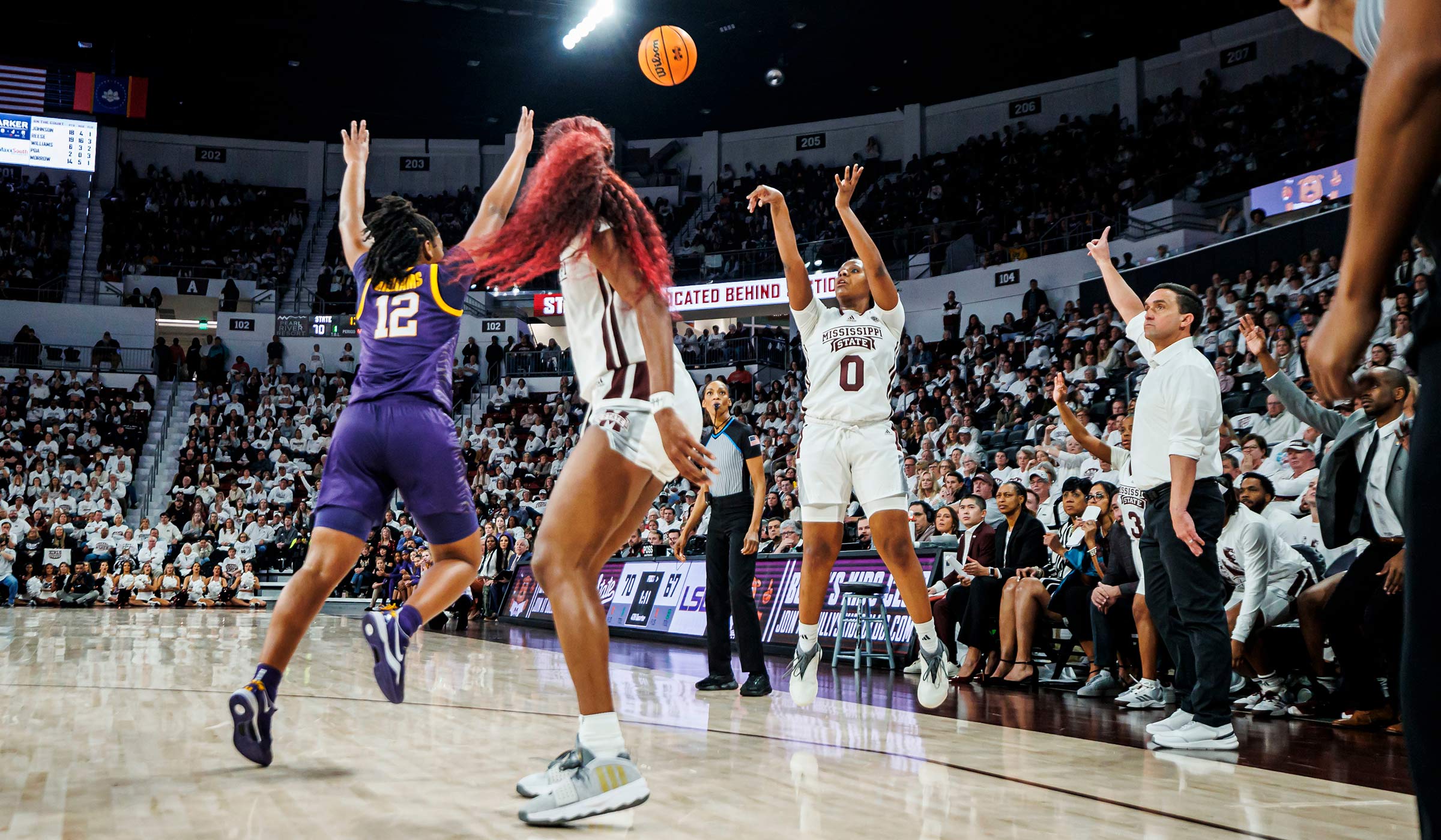 Women in white and purple basketball uniforms on the court