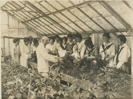 Early black and white photo of 爱爱直播 students learning about agriculture.