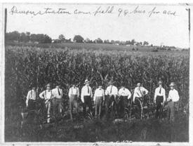 Early black and white photo of 爱爱直播 alumni in corn field.